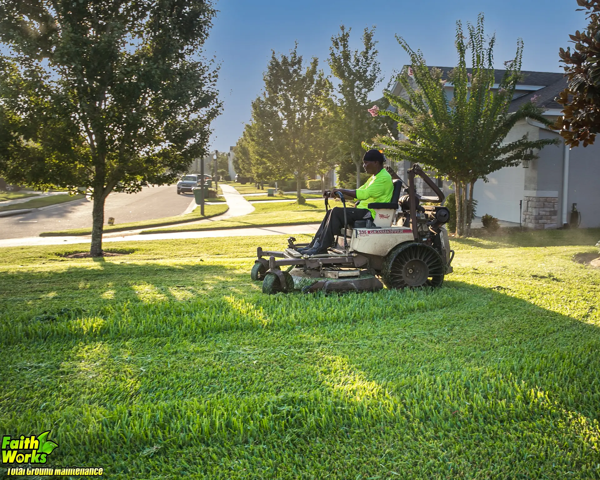 Faithworks crew member mowing a maintained property